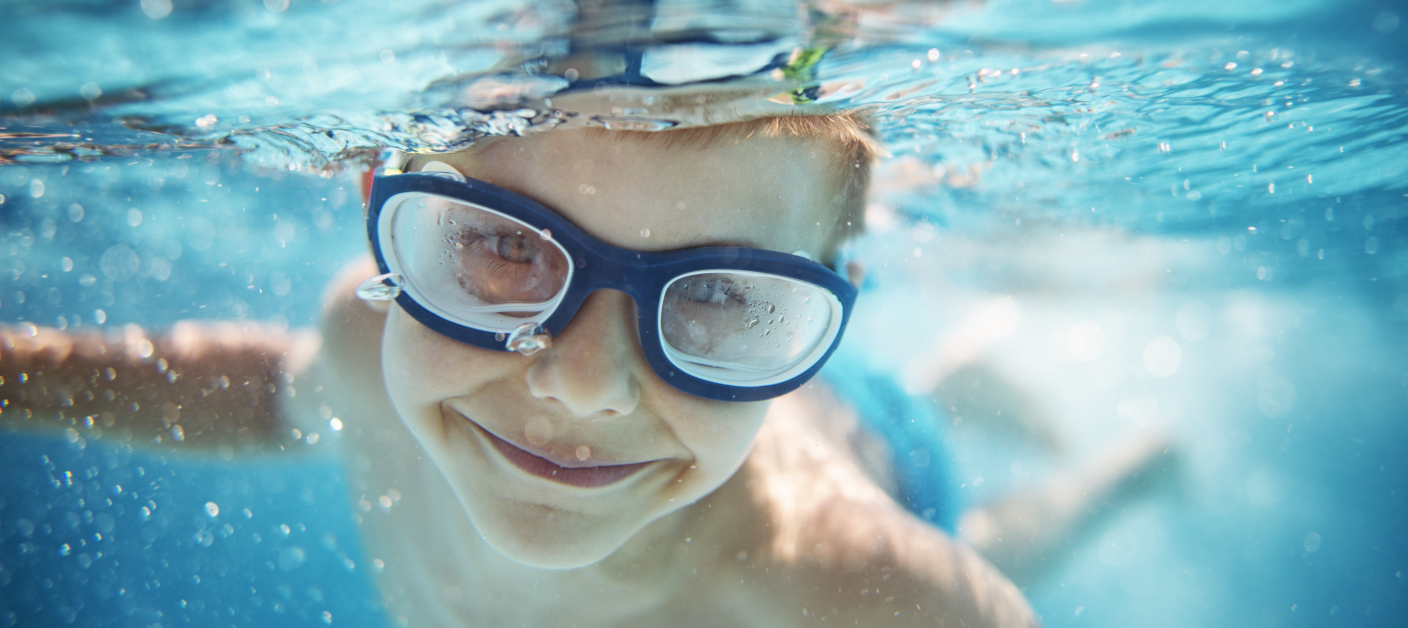Little boy swimming underwater in pool