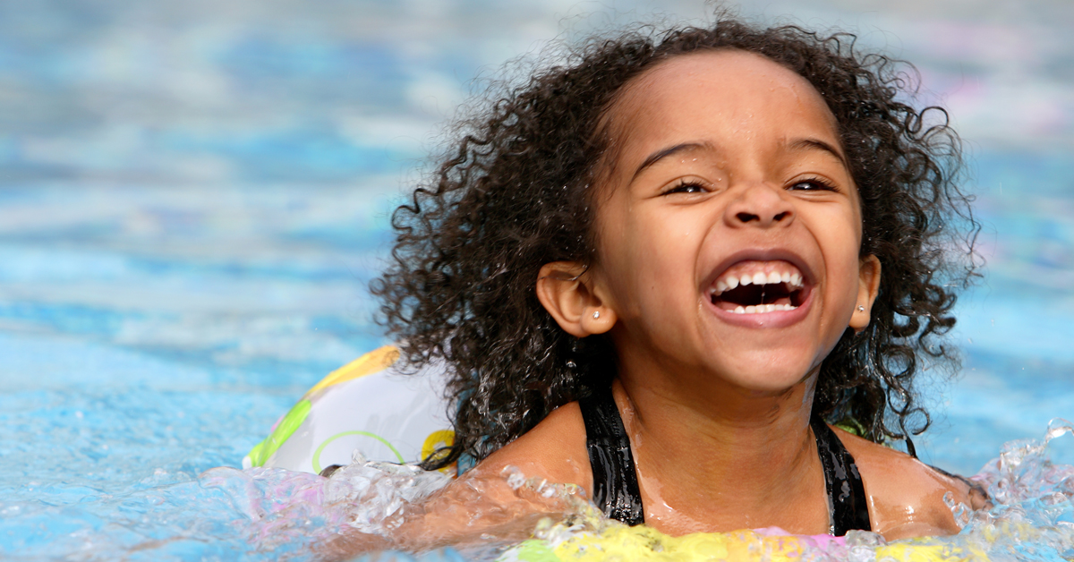 A jubilant kid swimming in a pool