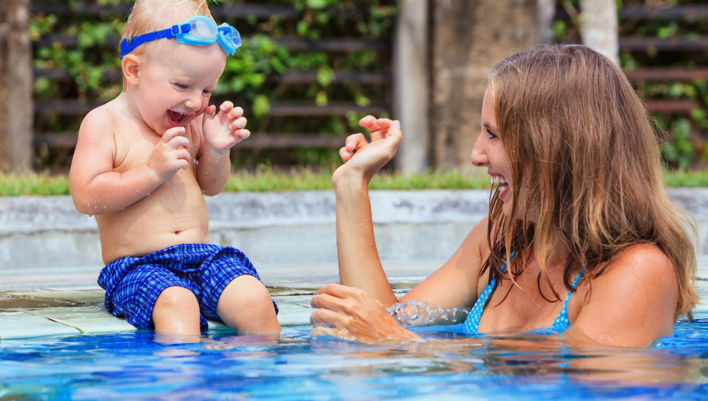 Happy child swim with beautiful mother in pool